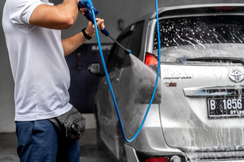 Pria cuci mobil cepat pakai air tekanan tinggi 130 bar di tempat cuci mobil sendiri self carwash