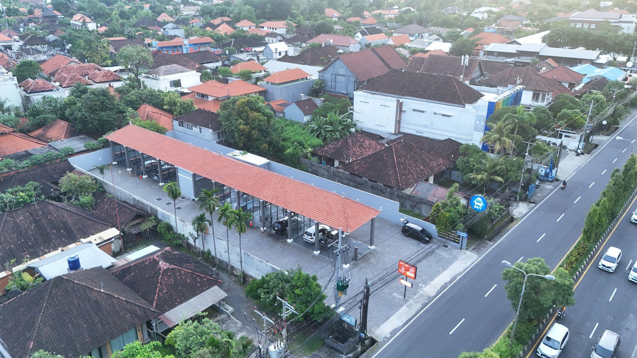 Pemandangan drone outlet franchise self car wash Indonesia di pinggir jalan raya utama akses mudah untuk driver taksi online dan kendaraan pribadi