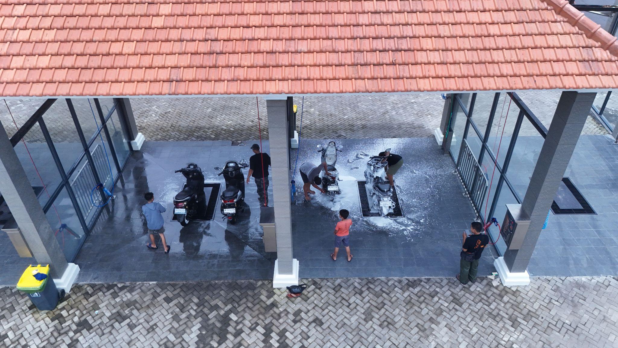 Area self service cuci motor di Self Car Wash Bali, pengendara sedang mencuci motor.